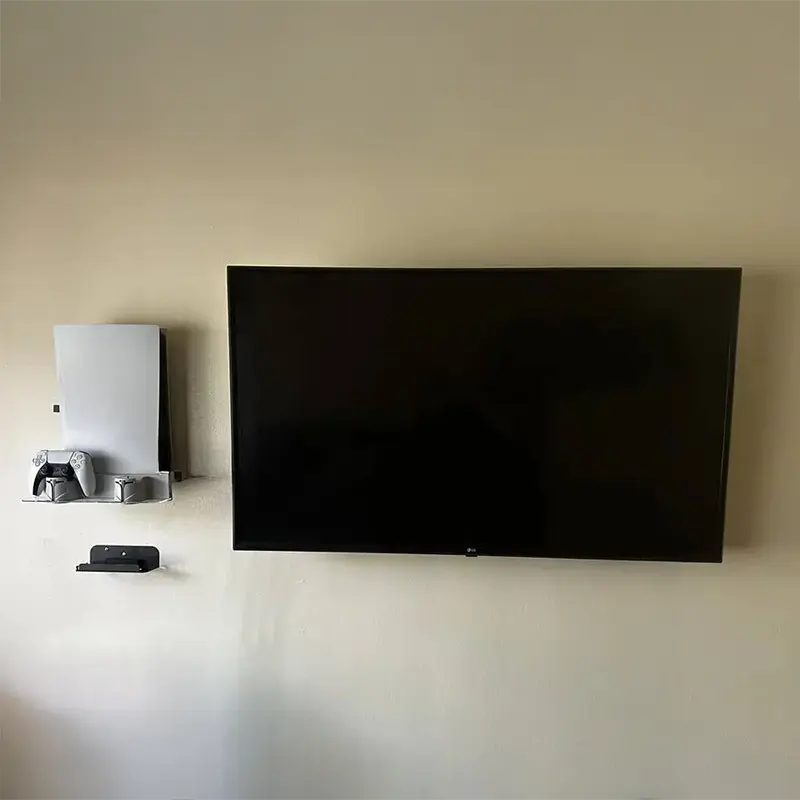 PlayStation 5 mounted on wall to the left of TV, all cables hidden in wall