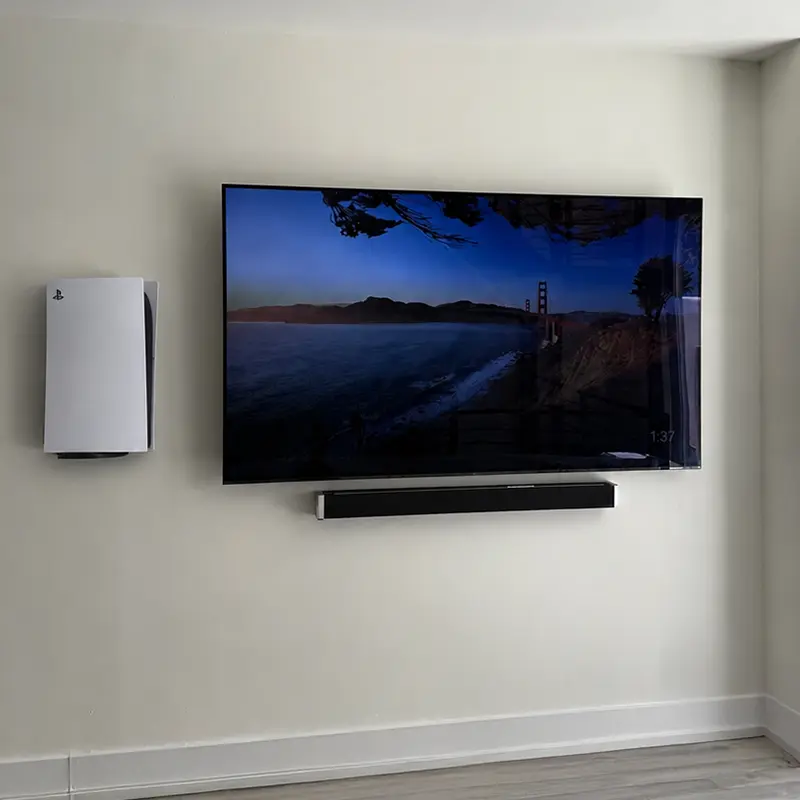 PS5 mounted to the left of TV with soundbar below, all cables concealed in wall