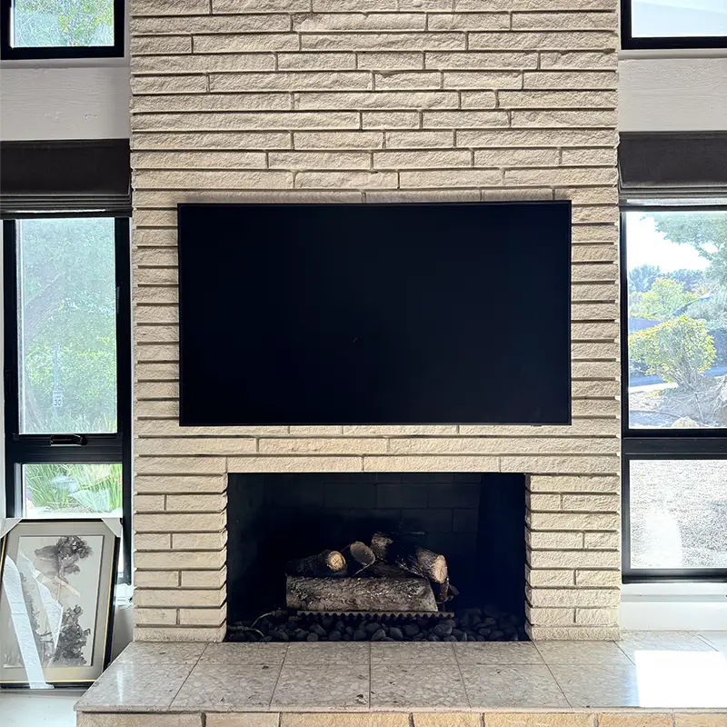 Samsung Frame TV mounted above brick gas fireplace with recessed box, no visible wires