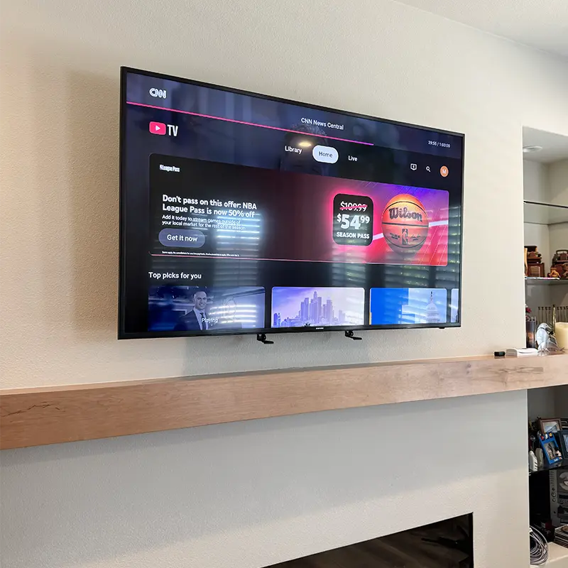 Samsung Frame TV on MantelMount pull-down bracket above fireplace, hidden cables
