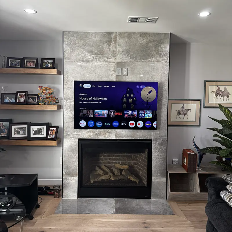 TV mounted above tiled fireplace with clean cable management