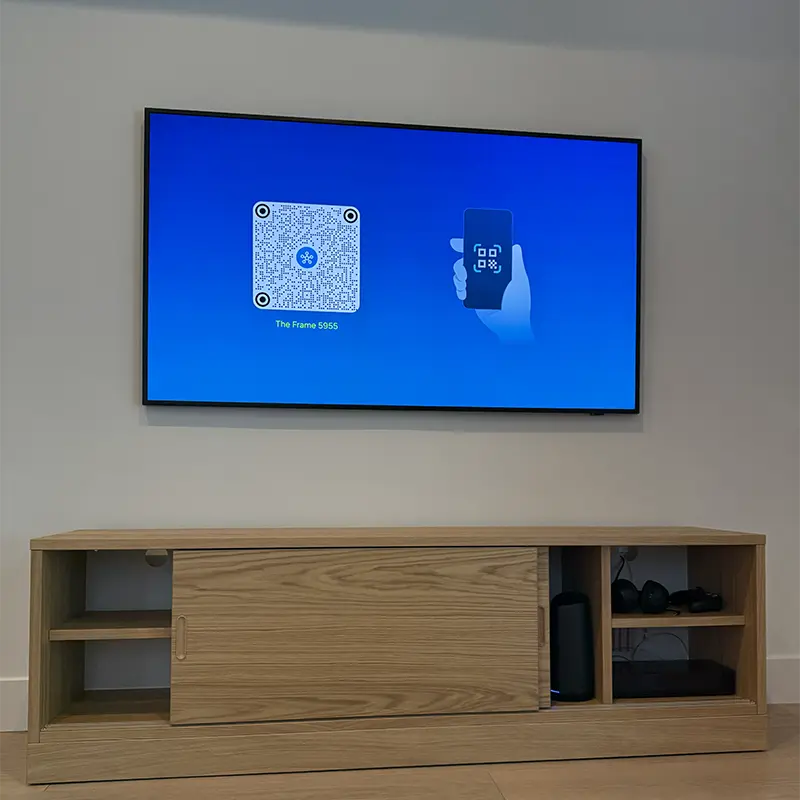 Samsung Frame TV above media console with One Connect Box hidden inside, cables through wall