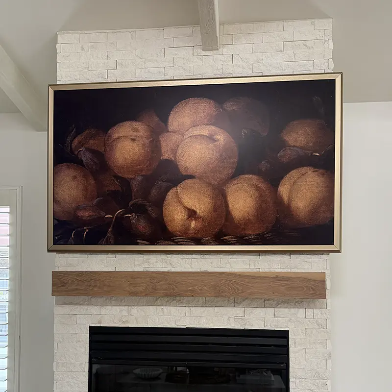 Samsung Frame TV mounted above fireplace, One Connect cable routed through fireplace cavity