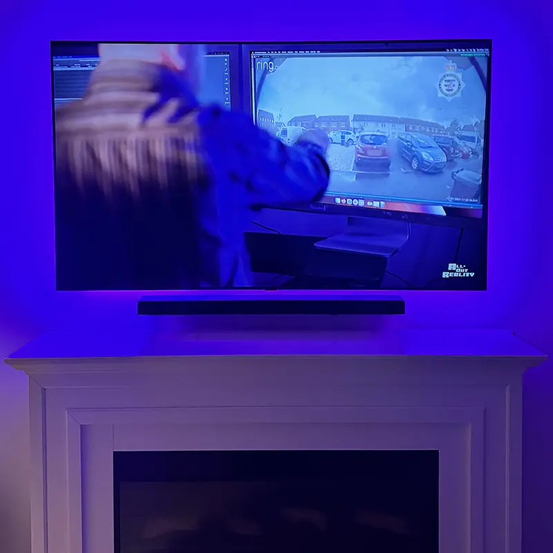 TV above fireplace with soundbar and smart LED backlighting for ambient effect