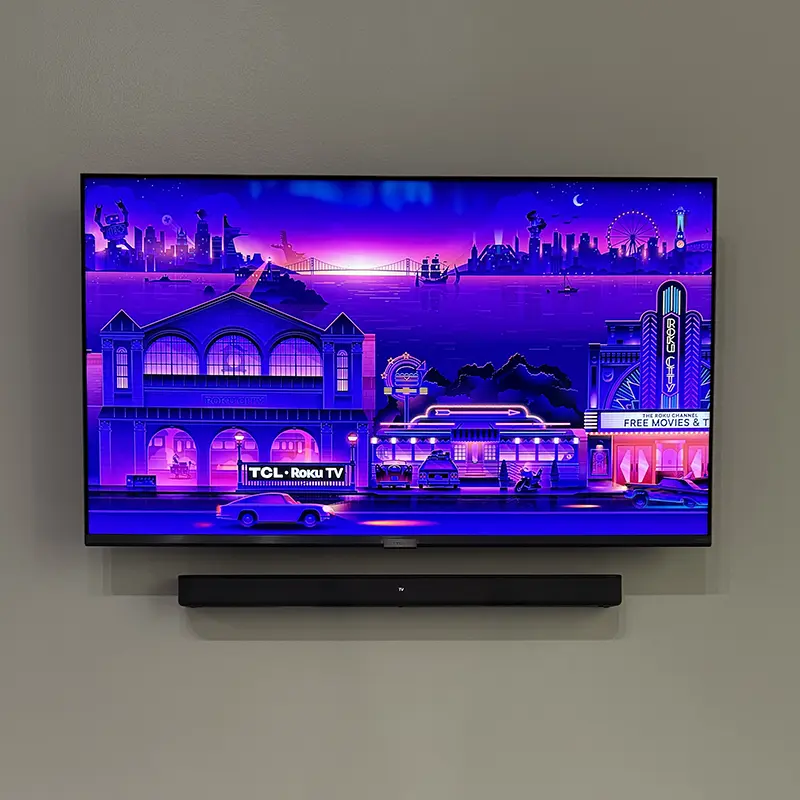 TV with soundbar mounted below on flat wall mount, all cables hidden in wall
