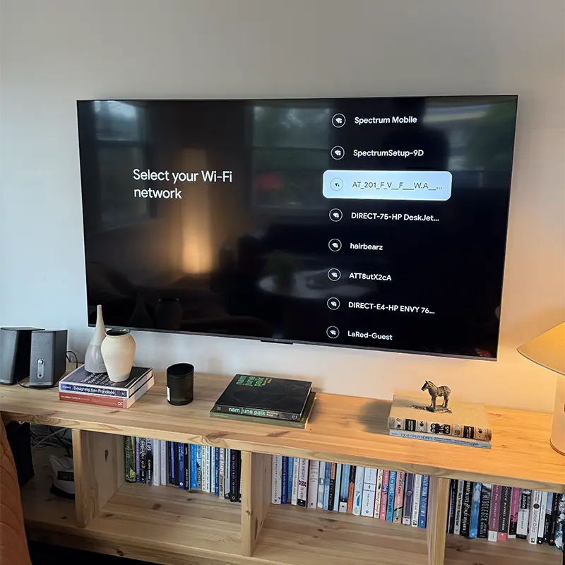 TV mounted above built-in shelving unit with no visible wires