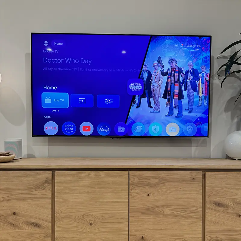 65-inch TV mounted above a media console with cables concealed inside the wall