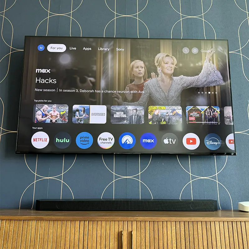 TV mounted with soundbar inside console, power and HDMI cables hidden in the wall
